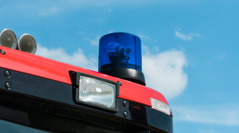 Folgetonhörner (auch als Tonfolgehörner) und blaue Rundumleuchte (oder Drehlicht) auf einem Feuerwehrauto vor blauem Himmel.