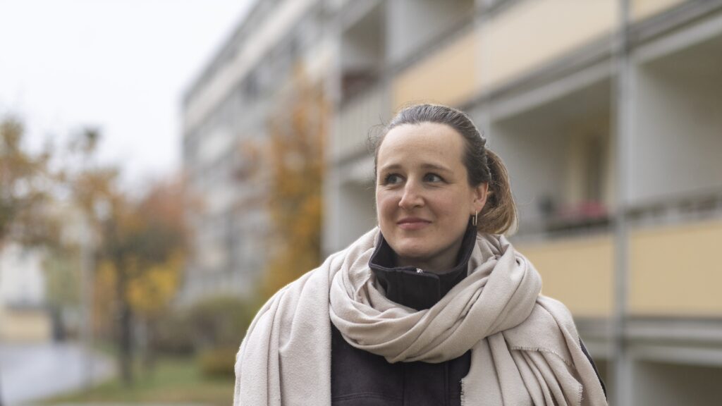 Constanze Kummer vor einem Wohngebäude.