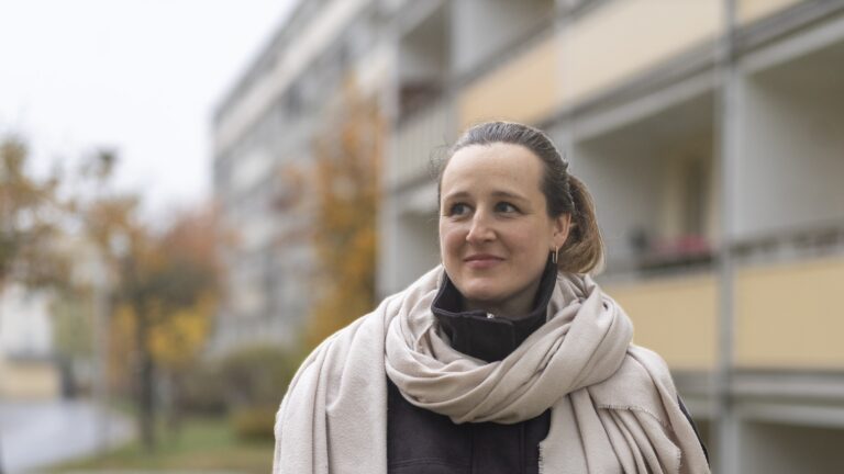 Constanze Kummer vor einem Wohngebäude.
