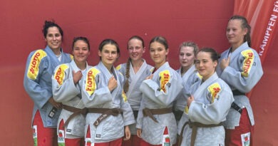 Die Frauenmannschaft von KSC ASAHI Spremberg vor einer roten Wand